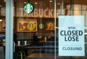 Interior of a Starbucks shop with a closure sign visible outside.